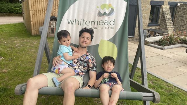 Richard and his two boys sitting on a branded Whitemead Forest Park giant deck chair
